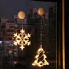 Christmas lights in the shape of a snowflake and a Christmas tree hanging on a window at dusk. Podgląd zdjęcia produktu