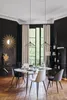 A dining room with a round marble table and chairs, set for a meal, with decorative elements like a sunburst mirror and a tall bookshelf. Podgląd zdjęcia produktu