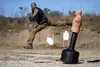 A man is practicing martial arts by kicking a BOB dummy in an outdoor setting with target boards in the background. Podgląd zdjęcia produktu