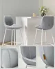 Two modern gray bar stools with white legs are placed next to a white marble-topped counter. Náhled obrázku produktu