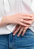 A close-up shot of a person's hands wearing jewelry, including rings and a bracelet, against a white background. Anteprima dell’immagine prodotto
