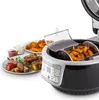 An air fryer filled with french fries and plates of food next to it. Produktbild-Vorschau