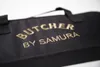 A close-up of a black bag with gold lettering. Náhľad obrázku produktu