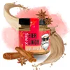 A jar of Christmas egg liqueur with festive decorations and ingredients like cinnamon sticks and star anise, surrounded by splashes of cream. Produktbild-Vorschau
