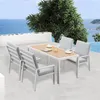 An outdoor dining set with a table and four chairs is placed on a patio overlooking the ocean. Produktbild-Vorschau
