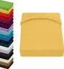A stack of folded sheets in various colors is shown on the left, and a single yellow fitted sheet is displayed on the right. Produktbild-Vorschau