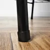 Close-up of the black metal leg of a garment rack with a black rubber foot on a wooden floor. Náhled obrázku produktu