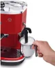 A hand is holding a milk frothing pitcher under the steam wand of a red espresso machine. Podgląd zdjęcia produktu