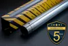 A motorcycle fork tube and its packaging are displayed on a dark surface, with a warranty badge. Produktbild-Vorschau