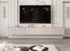 A modern living room with a TV mounted on a marble wall above a beige media console. The TV screen displays credits. Produktbild-Vorschau