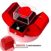 Rote herzförmige Geschenkbox, geöffnet, mit einer roten konservierten Rose in einer Acrylbox und einer goldenen Kleeblatt-Halskette, mit kleiner roter Geschenktüte in der Ecke Náhľad obrázku produktu