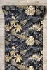 A rug with a tropical leaf pattern is laid on a wooden floor. Produktbild-Vorschau