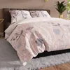 A close-up view of a bed with floral patterned bedding. Produktbild-Vorschau
