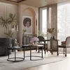 A modern living room setup with coffee tables, chairs, and plants. Voir les images du produit