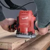 A person is using a Makita router on a wooden surface. Produktbild-Vorschau