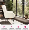 A cozy armchair in a living room setting with a large window view of trees. Náhled obrázku produktu