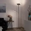 A modern living room with a black leather sofa, a side table with a vase of flowers, and a tall LED floor lamp. Produktbild-Vorschau