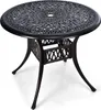 A round, dark brown, cast aluminum outdoor dining table with an ornate, openwork design on the tabletop and a decorative, lattice-like pattern on the base. Produktbild-Vorschau