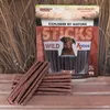 A bag of dog treats with some treats laid out in front of it, set against a background of dried grass. Produktbild-Vorschau