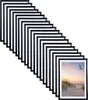 A stack of black picture frames arranged diagonally, with one frame showing a beach scene at sunset. Produktbild-Vorschau