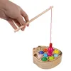 A hand holding a wooden fishing rod over a wooden cat-shaped fishing game with colorful fish. Náhled obrázku produktu