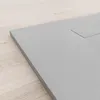 A close-up, angled view of a gray shower tray on a light wood floor. Produktbild-Vorschau