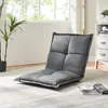 A floor chair is placed on a rug in a room with a plant and a cabinet. Voir les images du produit