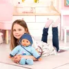 A young girl is lying on the floor with a baby doll. Produktbild-Vorschau