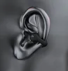 A close-up of a black earbud inserted into a metallic, abstract representation of a human ear. Produktbild-Vorschau