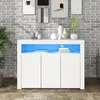 A white sideboard with LED lighting is displayed in a room with a brick wall and artwork. Anteprima dell’immagine prodotto