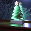 A decorative LED Christmas tree light with an infinity effect sits on a windowsill at night. Produktbild-Vorschau