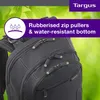 A close-up view of a black backpack with green accents, set against a blurred green leafy background. Náhľad obrázku produktu