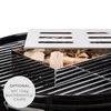 A close-up view of a smoker box filled with wood chips placed on a grill grate. Náhled obrázku produktu