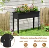 A raised garden bed filled with colorful flowers, placed on a lawn in front of a white fence and wooden fence. Voir les images du produit