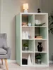 A white cube shelving unit with light green accents, decorated with various items and plants. Produktbild-Vorschau
