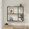A black metal wall shelf with multiple compartments, decorated with framed pictures, plants, and decorative items, mounted on a light-colored wall above a wooden desk. Náhled obrázku produktu