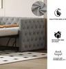 A close-up view of a grey upholstered daybed with tufted detailing and nailhead trim, next to a rug with a diamond pattern. Icons and text highlighting product features are on the right side. Produktbild-Vorschau