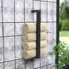 A black metal towel rack with four rolled beige towels mounted on a tiled wall outdoors. Anteprima dell’immagine prodotto