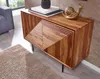 A wooden sideboard with a decorative snail figurine on top, placed in a living room setting with a rug and part of a sofa visible. Náhled obrázku produktu