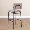 A bar stool is shown in a room with a light-colored wall and wooden floor. Produktbild-Vorschau