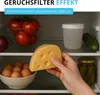 An open refrigerator shelf with various food items and a product overlay advertising a 'odor filter effect'. Produktbild-Vorschau