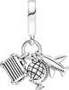 A close-up studio shot of a Pandora charm featuring a plane, globe, and suitcase. Podgląd zdjęcia produktu