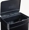 A close-up view of the top of an open black sensor trash can. Voir les images du produit