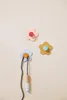 Three flower-shaped wall hooks on a plain background, with a jump rope hanging from one. Produktbild-Vorschau