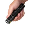 A hand holding a black Nitecore MH12 Pro flashlight. Produktbild-Vorschau
