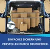 Boxes are loaded into the back of a dark blue van, secured by metal bars. Produktbild-Vorschau