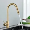 A gold kitchen faucet with water running into a sink. Produktbild-Vorschau