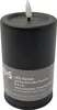 A black LED candle with a flickering flame and product information on a label. Produktbild-Vorschau