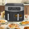 A dual-chamber air fryer is shown on a kitchen counter, surrounded by plates of food and a drink. Produktbild-Vorschau