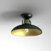 A ceiling light fixture with a black shade and gold interior, mounted on a white ceiling. Produktbild-Vorschau